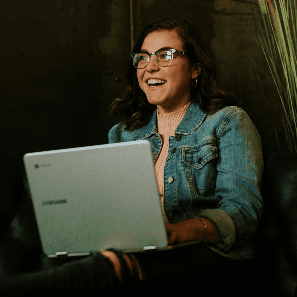 An single person smiling and using a laptop.